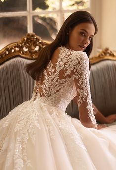 a woman in a wedding dress sitting on a couch