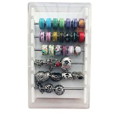 a display case filled with lots of different colored bracelets and rings on top of each other