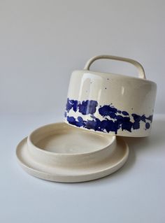 two white and blue dishes with one bowl on the other, sitting next to each other