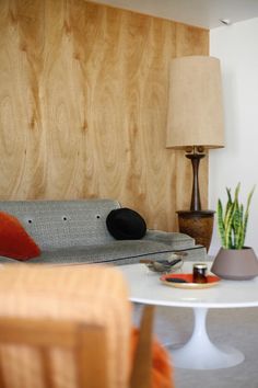 a living room with a couch, table and lamp in it's centerpiece