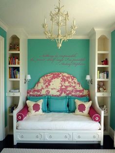 a bedroom with blue and pink walls, white furniture and a chandelier hanging from the ceiling