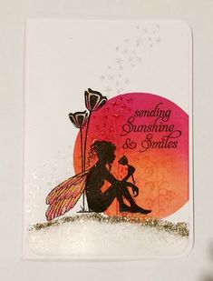 a card with the silhouette of a fairy holding a flower and sitting on top of it