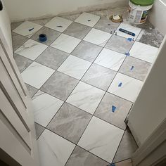 a bathroom floor that is being remodeled with blue tape on the ground and white walls