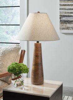 a table with a lamp and vase on it