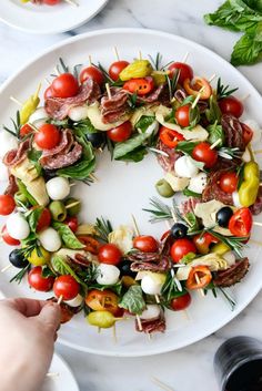 a white plate topped with meat and veggies on skewers