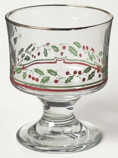 a glass bowl with holly and berries painted on the bottom is sitting on a white surface