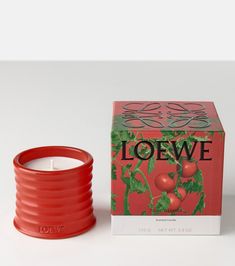 a red candle sitting next to a box of loewe candles