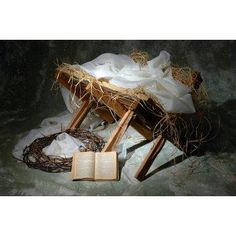 an open book sitting on top of a wooden chair next to a white cloth covered blanket