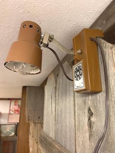 a light that is on the side of a wooden wall next to a lamp shade