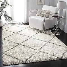 a living room with a white chair and rug