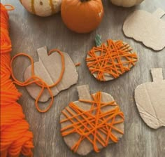 pumpkins and other crafting supplies sitting on a table next to some orange string