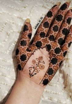 a woman's hand with hennap on it and flowers painted on the palm