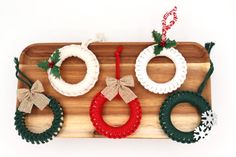 three wreaths are hanging on a wooden tray