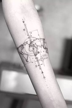 a black and white photo of a world map tattoo on the left inner arm with lines