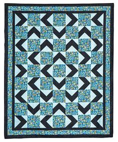 a blue and black quilt with an arrow design on it's center, in the middle