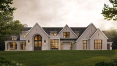 a large white house sitting on top of a lush green field