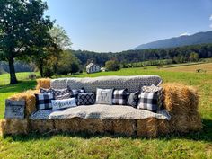 a couch made out of hay sitting on top of a field