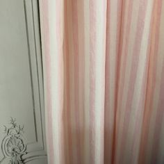 pink and white striped curtain hanging on the side of a door