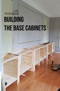 the base cabinets are being built in this room with wood flooring and white walls