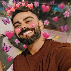 a man with hearts painted on his face in front of pink flowers and butterflies around him