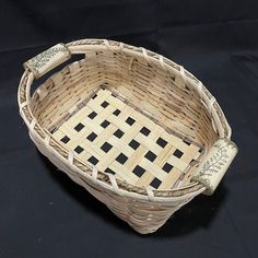 a wicker basket with black and white checkers on the bottom is sitting on a black surface