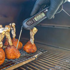 someone is using a thermometer to check out some meats on a grill