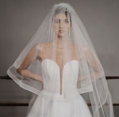 a woman in a wedding dress with a veil on her head