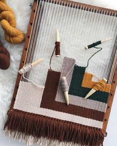 two skeins of yarn sitting on top of a weaving machine