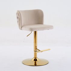 a white and gold colored bar stool with an arm rests on a round metal base