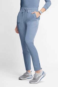 So sleek! These pants have a tapered shape with ankle zips. (Makes them easier to get on. ) Grosgrain ribbon trim at the front pocket edges and center back waist adds a little extra interest. And 5 pockets let you carry the essentials. WhisperLite may be your coolest-feeling scrubs ever. Feather light poplin with wicking and 4-way stretch that also repels lint, fur, and hair. And with extra chic, feminine styling, they look cool too. • Modern fit • Tapered leg shape • Elastic waist with elastic Med Couture Scrubs, Carhartt Scrubs, Healing Hands Scrubs, Leg Scrub, Koi Scrubs, Scrub Style, Greys Anatomy Scrubs, Indigo Batik, Scrub Jackets