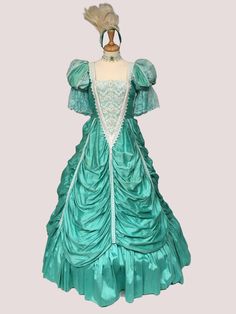 Princess dress 18th Century Dress, Rococo Dress, Aqua Silk Marie Antoinette Inspired Dress The romance of 18th century fashion is clearly shown in this  aqua silk gown.  This dress is designer made in the 1980s by costume designer Ray Buchanan. The base of the dress is aqua shantung silk with lace ruffles at the sleeves. The front bodice has lace overlay in the classic Marie Antoinette style. The top skirt has draped ruching and attaches to the bodice. The underskirt has a drawstring waist for a Vintage Blue Baroque Dress, Blue Vintage Baroque Dress, Blue Baroque Vintage Dress, Elegant Green Dress With Historical Design, Elegant Green Victorian Costume Dress, Victorian Baroque Dress With Fitted Bodice, Blue Baroque Dress With Historical Design, Blue Vintage Victorian Dress With Baroque Style, Blue Vintage Victorian Dress In Baroque Style