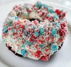 a close up of a doughnut on a white plate with sprinkles