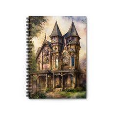 a spiral notebook with a painting of an old house