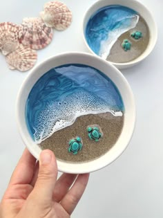 two bowls filled with sand and sea shells