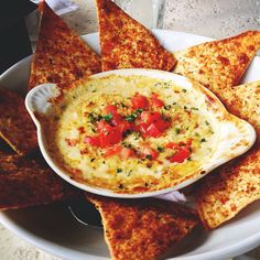 a white plate topped with chips and dip