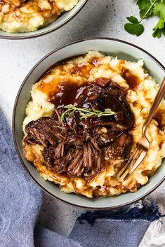 two bowls filled with mashed potatoes topped with beef and gravy on top