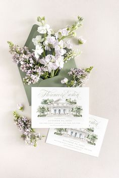 wedding stationery with flowers and greenery in front of an envelope on a white background