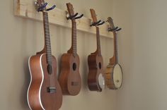 three ukulele hanging on the wall with other musical instruments