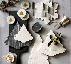 christmas decorations are laid out on a table with utensils and other holiday items