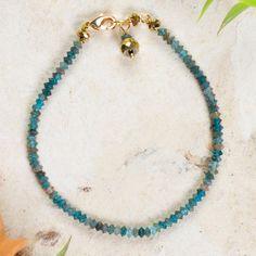 The magic of the ocean can be with you whenever you want with this beautiful apatite bracelet. Designed and crafted by Mexican artisan Patricia Guzman, its faceted gemstones shimmer in shades of blue-green. Hematite adorns he clasp, which is covered in 14k gold. Turquoise Apatite Spiritual Bracelets, Apatite Bracelet, Strand Bracelet, Faceted Gemstones, Shades Of Blue, The Ocean, The Magic, Blue Green, Jewelry Bracelets