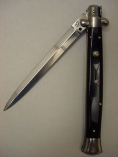 a black and silver pocket knife laying on top of a table