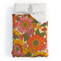 an orange and pink flowered comforter with white pillows