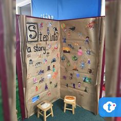 a room divider made out of cardboard with stickers on it and a child's chair in the corner