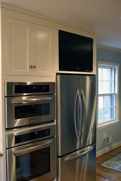 a kitchen with stainless steel appliances and white cabinets