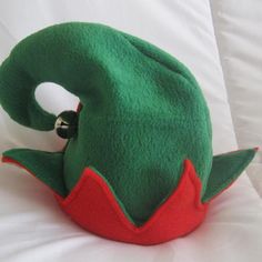 a green and red stuffed animal sitting on top of a bed