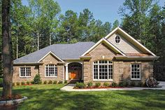 a brick house surrounded by trees and grass