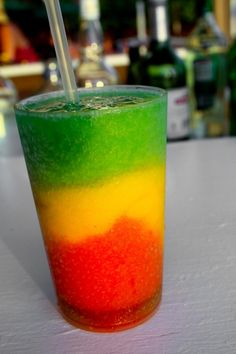 a colorful drink with a straw sticking out of it's top sitting on a table