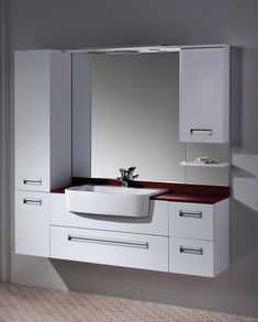 a white sink sitting under a large mirror next to a wall mounted faucet