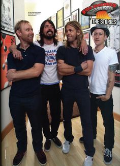 three men standing next to each other with their arms around one another in front of a store window