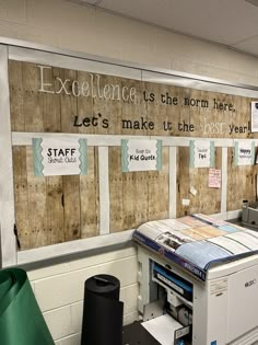 an office cubicle is decorated with wood planks and paper taped to the wall